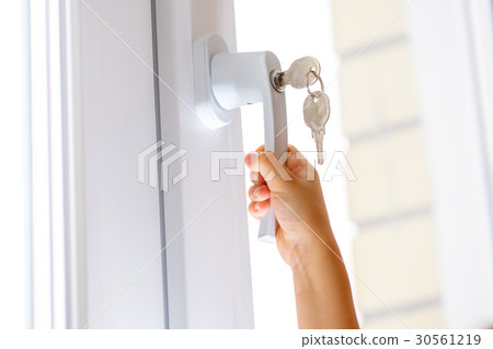 Child's hand on secure window handle Child's hand on secure window handle 30561219