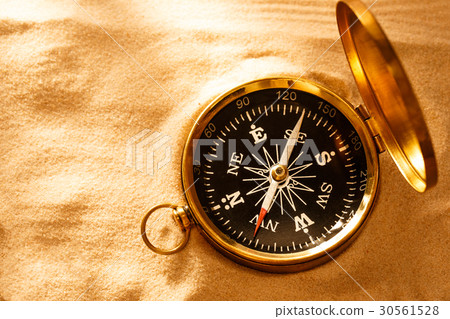 Golden compass with beach sand Golden compass with beach sand 30561528