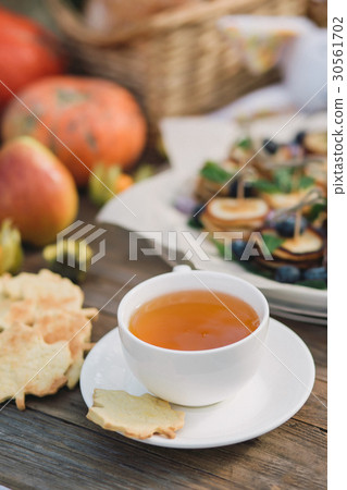 White cup with tea and cookies on a wooden table White cup with tea and cookies on a wooden table 30561702