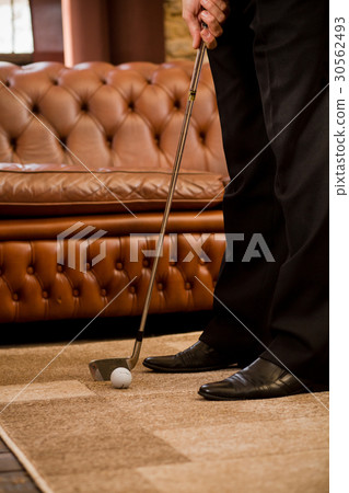 Man playing golf at home Man playing golf at home 30562493