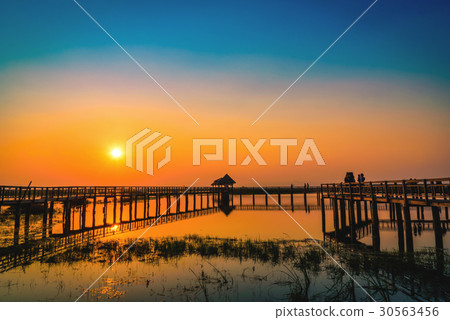 Silhouette old wooden bridge and pavilion in lake Silhouette old wooden bridge and pavilion in lake 30563456