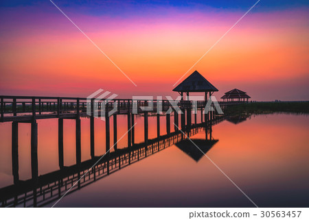Silhouette old wooden bridge and pavilion in lake Silhouette old wooden bridge and pavilion in lake 30563457