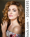 Beautiful young woman with long red curvy hair 30564395