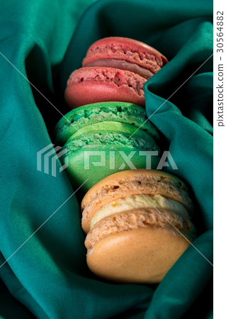 Three macaroons on green background. French 30564882
