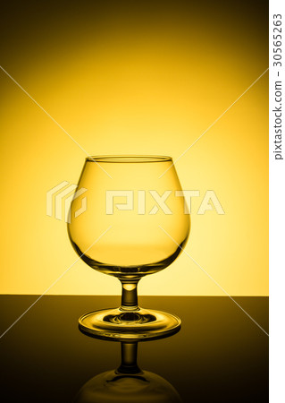 Empty wine glass on yellow background Empty wine glass on yellow background 30565263
