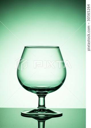 Empty wine glass on a green background Empty wine glass on a green background 30565264