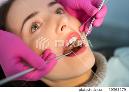 Dentist checking up patient teeth at dental clinic 30565379