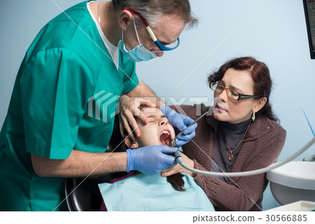 Pediatric dentist doing first check-up for patient 30566885