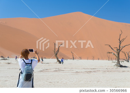 Tourist taking photo at Sossusvlei 30566966