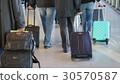 People rolling suitcases 30570587