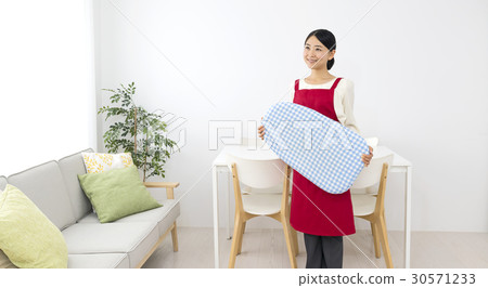 A smiling female apron with an iron A smiling female apron with an iron 30571233