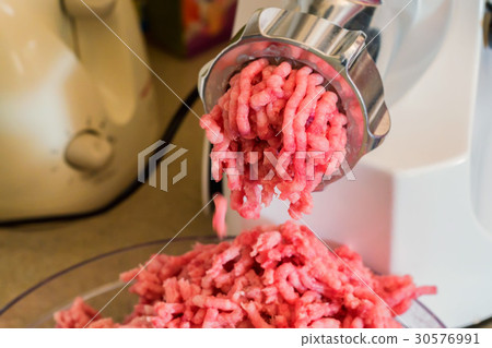 Close-up of minced meat coming out from grinder Close-up of minced meat coming out from grinder 30576991