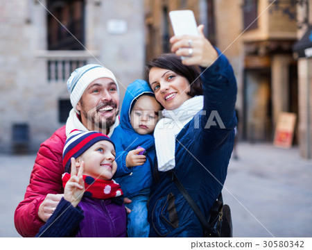 Family with children walking the city and doing selfie Family with children walking the city and doing selfie 30580342