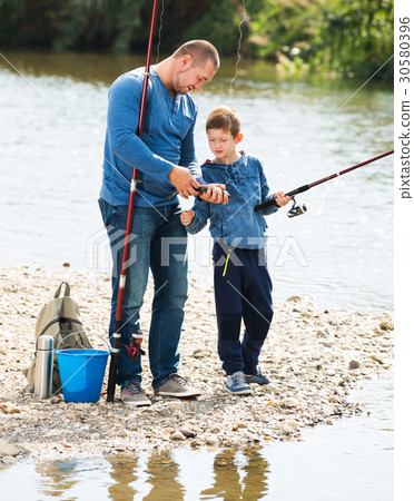 Man and little boy fishing 30580396