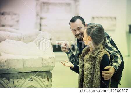 happy father and daughter regarding classical bas-reliefs in museum 30580537