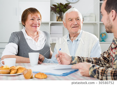 Aged couple signing agreement Aged couple signing agreement 30580752