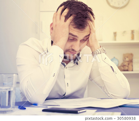 Man struggling to pay bills Man struggling to pay bills 30580938