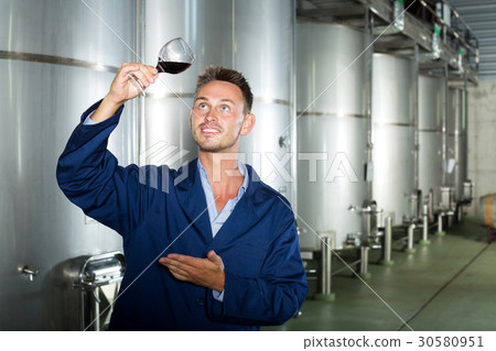 Man in uniform looking at wine 30580951