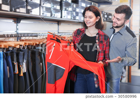 Positive couple examining touristic trousers 30580996