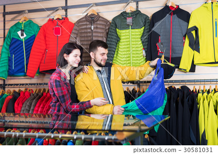 Couple examining windcheaters in store 30581031
