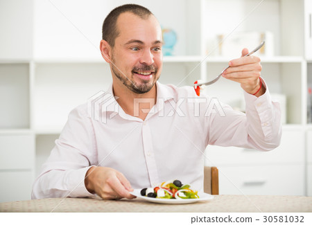 Smiling man looking at greek salad 30581032