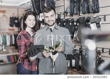 Young couple choosing protective gloves Young couple choosing protective gloves 30581065