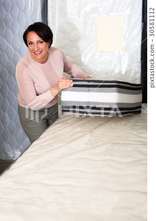 Brunette choosing sleeping mattress Brunette choosing sleeping mattress 30581112