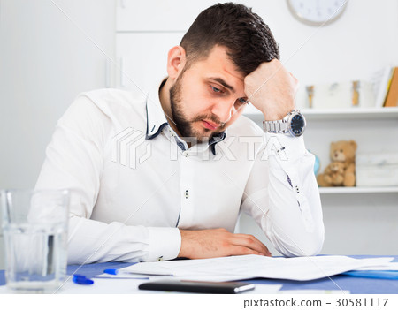 Young male worker having problem in project in office Young male worker having problem in project in office 30581117