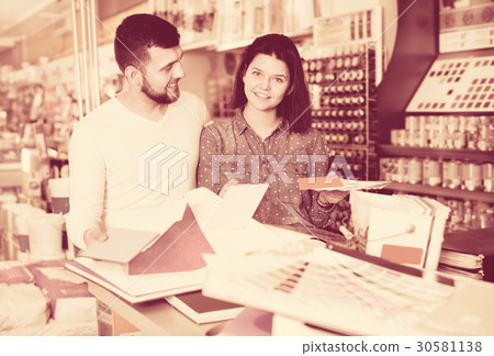 Couple examining various decorative materials 30581138