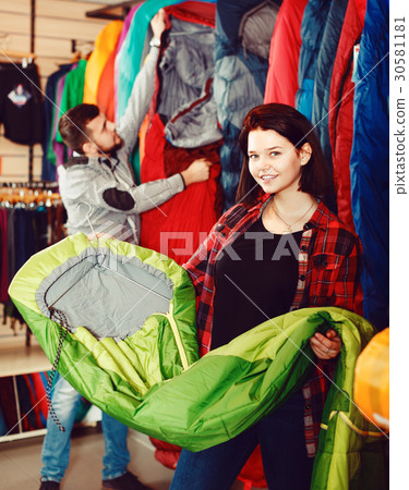 Woman shoosing new sleeping bag 30581181