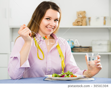 Young female is enjoying tasty green salad Young female is enjoying tasty green salad 30581304