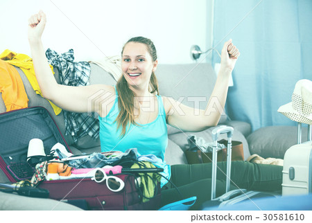 Happy girl traveler packing suitcase for holiday Happy girl traveler packing suitcase for holiday 30581610