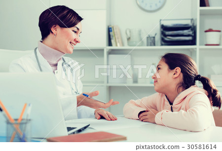 Doctor fills patient card for girl Doctor fills patient card for girl 30581614