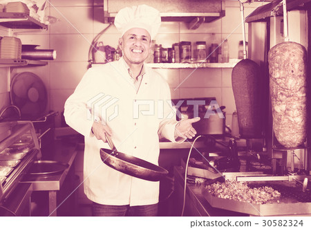 man cook making kebab dish on kitchen in fast food restaurant man cook making kebab dish on kitchen in fast food restaurant 30582324