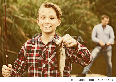 Fisher boy showing catch fish Fisher boy showing catch fish 30582325