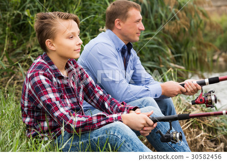 Positive family fishing together on freshwater river 30582456