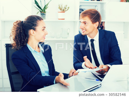 Two business male and female assistants wearing formalwear havin 30582546