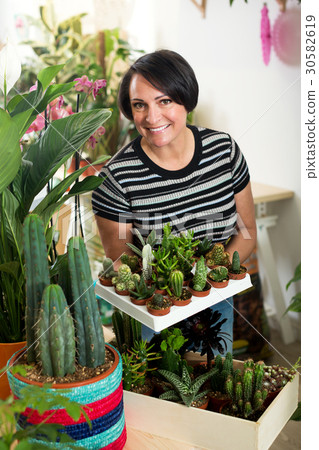 Woman holding a tray with cactuses Woman holding a tray with cactuses 30582619