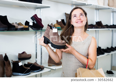 Portrait of cheerful woman selecting loafers 30582682