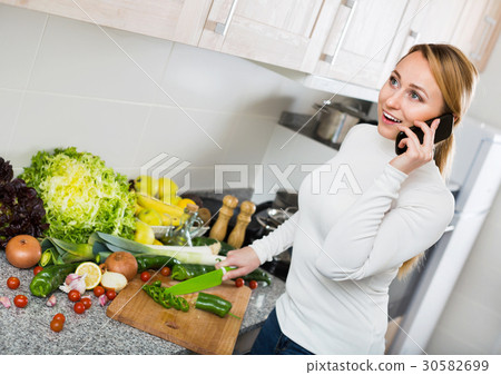 Portrait of smiling blondie in kitchen talking Portrait of smiling blondie in kitchen talking 30582699