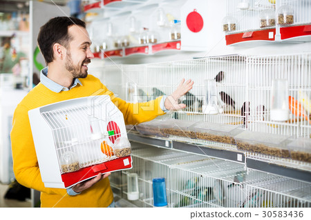 Smiling man choosing pretty bird Smiling man choosing pretty bird 30583436
