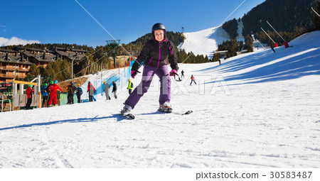 Woman wearing ski equipment and skiing in snowing mountains Woman wearing ski equipment and skiing in snowing mountains 30583487