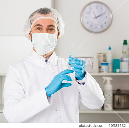 Male nurse preparing injection 30583582