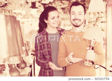 Guy and a girl choose a table lamp 30583756