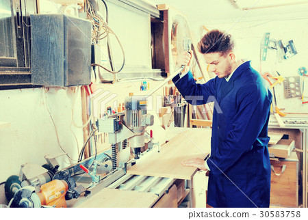 Working man preparing chipboard for work Working man preparing chipboard for work 30583758