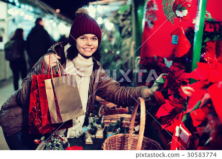 Girl buying floral compositions at Christmas market Girl buying floral compositions at Christmas market 30583774