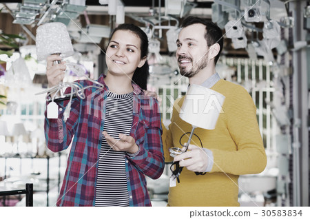 man and girl in lighter shop discussing purchase of bedside lamp for house man and girl in lighter shop discussing purchase of bedside lamp for house 30583834