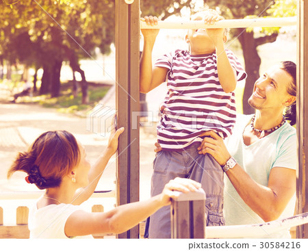 family with teenage son training on pull-up bar 30584216