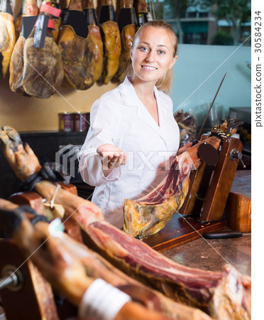 Adult woman in uniform selling prosciutto meat Adult woman in uniform selling prosciutto meat 30584234