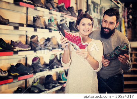 Couple deciding on new sneakers Couple deciding on new sneakers 30584317